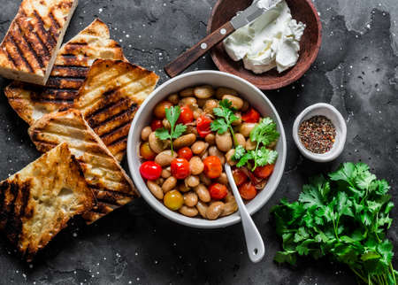 Ingredients for goats cheese crostini with garlicky beans on a dark background, top viewの写真素材