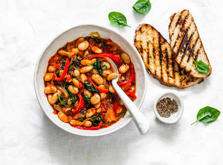 Greek style tomato sauce, spinach, paprika, beans stewed on a light background, top viewの写真素材