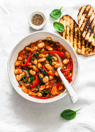 Greek style tomato sauce, spinach, paprika, beans stewed on a light background, top viewの写真素材