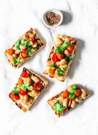 Goats cheese crostini with garlicky beans on a white background, top viewの写真素材