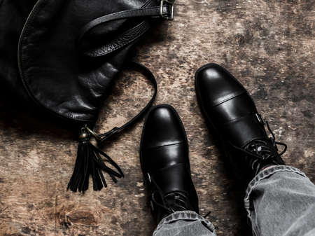 Black leather shoes, black leather bag on a wooden background, top view. Fashion conceptの写真素材