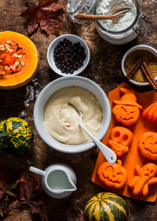 Halloween sweet fun baking background. Ingredients for making cupcakes on a wooden background, top viewの写真素材