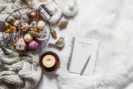 Vintage christmas toys, empty notepad christmas planning on a fluffy carpet, top view. Cozy home