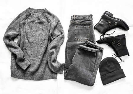 Cashmere gray sweater, jeans, black leather shoes, beanie hat - women's clothing on a light...