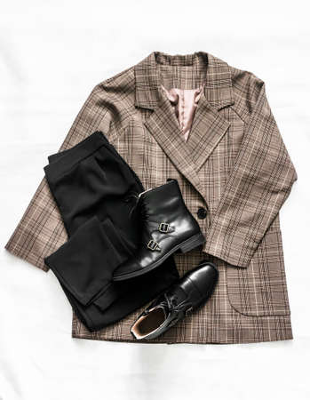 Women's clothing - plaid jacket, black trousers and leather shoes on a light background, top viewの写真素材