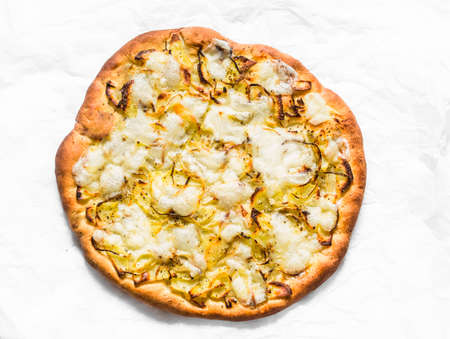 Potatoes, onions, mozzarella focaccia on a light background, top view. Vegetarian pizza with potatoes, onions and mozzarellaの写真素材