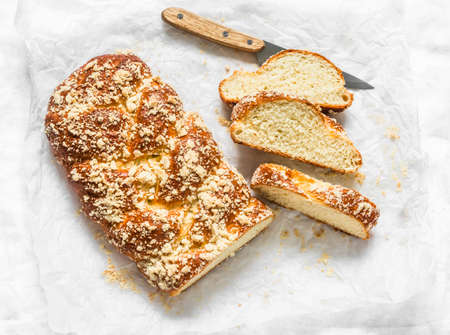 Slice of fresh homemade challah on a light background, top view