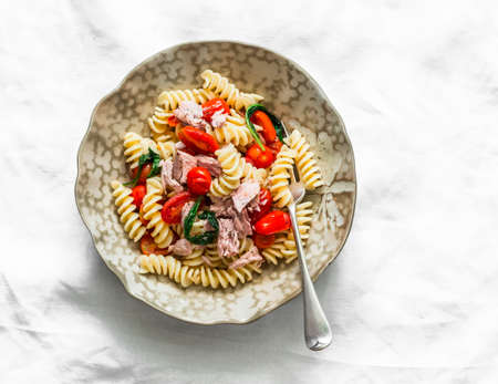 Sicilian fusilli pasta with canned tuna, cherry tomatoes and spinach on a light background, top viewの写真素材