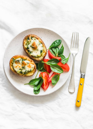 Roasted potatoes stuffed spinach and mozzarella on a light background, top view. Delicious tapas, snack, appetizersの写真素材