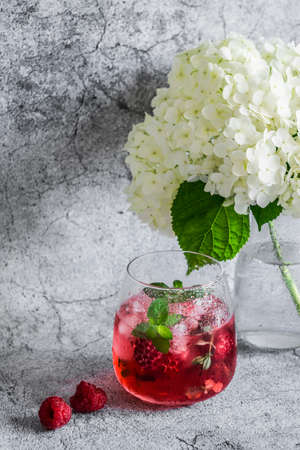 Raspberry mint cocktail refreshing drink and flowers on grayの写真素材