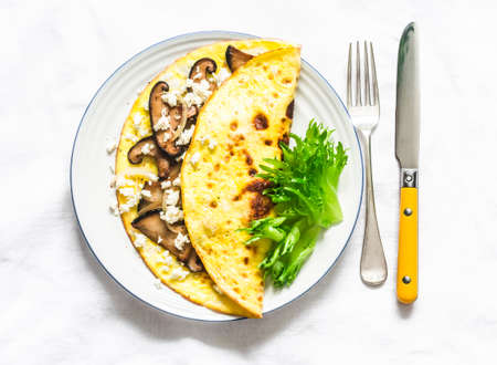 Omelet with shiitake and eringi mushrooms - delicious, healthy, vegetarian brunch on a light background, top viewの写真素材