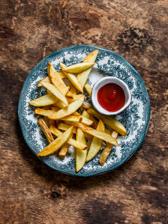French fries and ketchup on a wooden background, top viewの写真素材