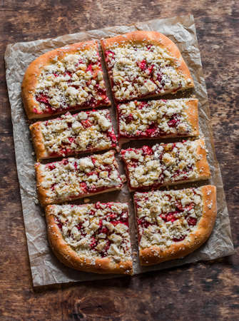 Strawberry yeast pie with crumble on a wooden background, top viewの写真素材