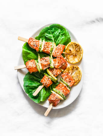 Salmon skewers with zucchini and sesame on a light background, top view. Delicious appetizer, tapas, lunchの写真素材