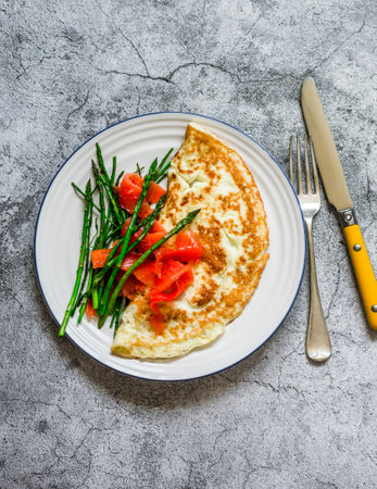 Delicious breakfast, brunch omelet with asparagus and smoked salmon on a gray background, top viewの写真素材