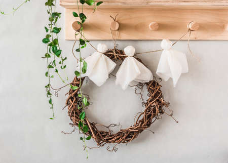 Halloween children's crafts - paper ghosts from napkins garland on a wooden hanger in the hallway. Creativity craft conceptの写真素材