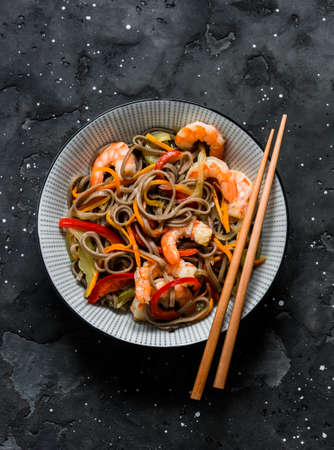 Buckwheat noodles with vegetables and shrimp on a dark background, top viewの写真素材