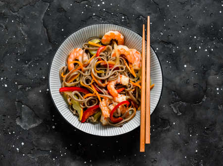 Buckwheat noodles with vegetables and shrimp on a dark background, top viewの写真素材