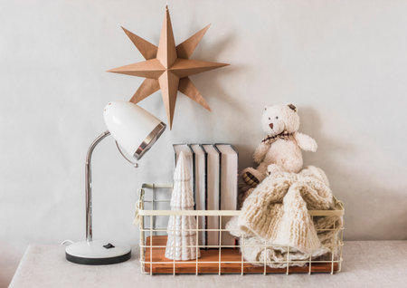 Cozy living room interior with christmas decorations, a basket with books, a knitted blanket on a tableの写真素材