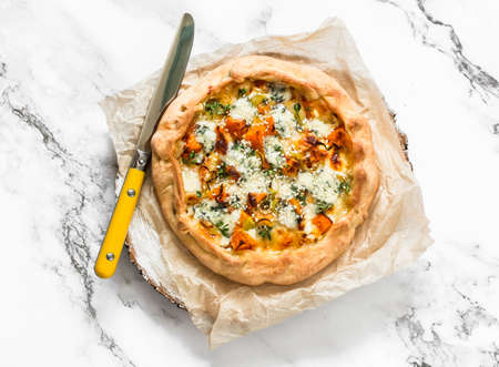 Pumpkin, leek, gorgonzola cheese crunchy pie on a light background, top view. Delicious tapas, snackの写真素材