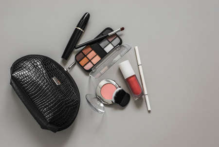 Decorative cosmetics, make up products, shadows, blush, mascara, lipstick on a gray background, top view. copy spaceの写真素材