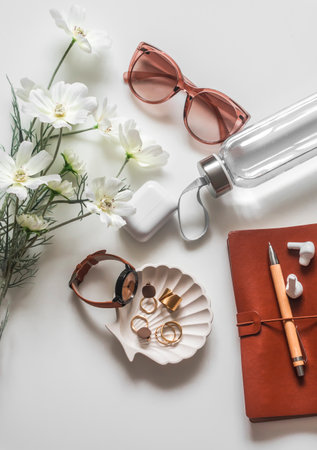 Female background - flowers, sunglasses, jewelry, notebook, water bottle on a light background, top viewの写真素材