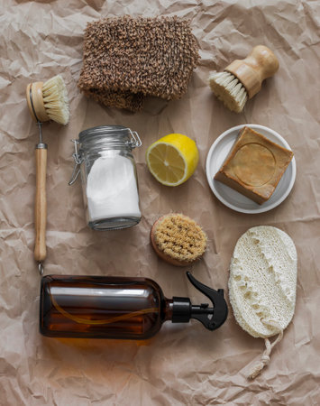 Natural organic cleaning products - soda, lemon, ammonia in a dispenser, natural homemade soap on a...