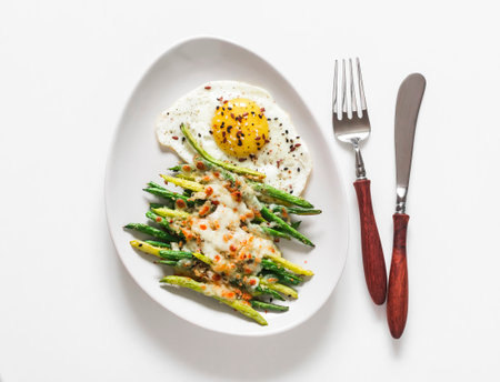 Mozzarella, lemon bread crumbs baked green string beans and fried egg on a light background, top viewの写真素材