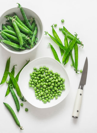 Young fresh green peas on a white background, top viewの写真素材