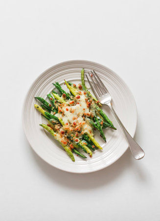 Grilled green string beans with mozzarella and lemon bread crumbs on a light background, top viewの写真素材