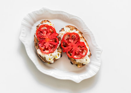 Stracciatella cheese, bruschetta tomatoes on a light background, top viewの写真素材