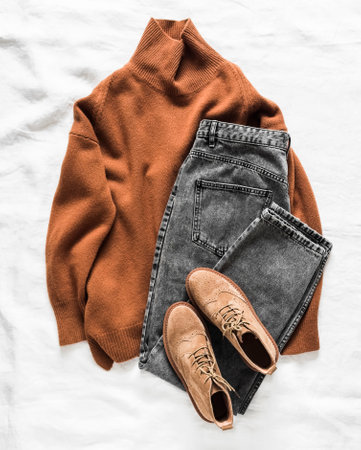 Cashmere sweater, mom's jeans, suede shoes - a set of women's clothing on a light background, top viewの写真素材