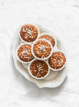 Almond flour muffins with pearl sugar on a plate on a light background, top viewの写真素材