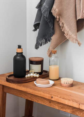 Simple bathroom interior - cotton towels on the wall, hygiene supplies on a wooden benchの写真素材