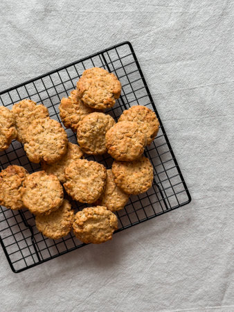 Oatmeal cookies on a metal baking rack on a gray background, top view