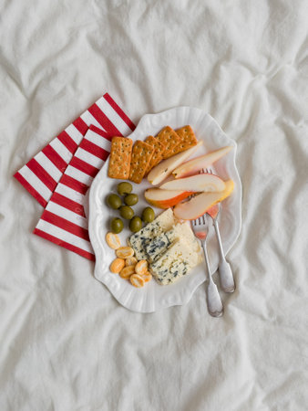 Delicious appetizer, tapas - cracker, olives, gorgonzolla, pear on a light background, top view