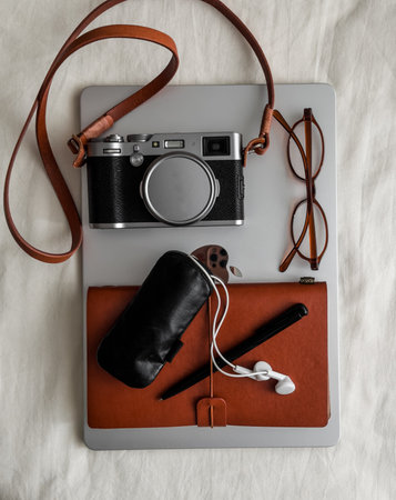 Aesthetic accessories - retro-style camera, laptop, notebook, headphones, glasses on a light background, top viewの写真素材