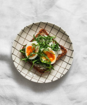 Sandwich with boiled egg, arugula on a light backgroundの写真素材