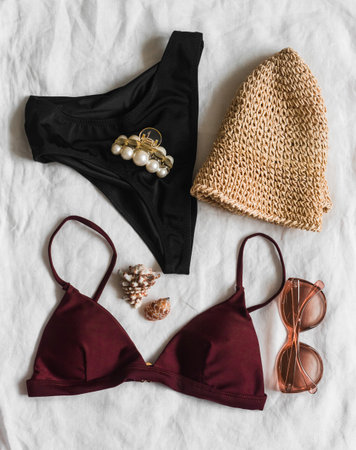 Women's swimsuit bikini, hat, sunglasses, accessories on a light background, top view