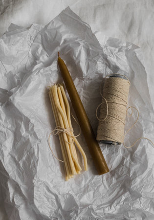 Handmade candles, rope - cozy details of the interior of the house on a light paper background, top viewの写真素材