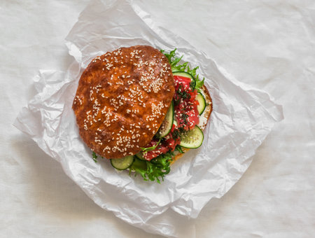 Sandwich with cucumber, green salad, cream cheese in a flatbread on a light background, top viewの写真素材