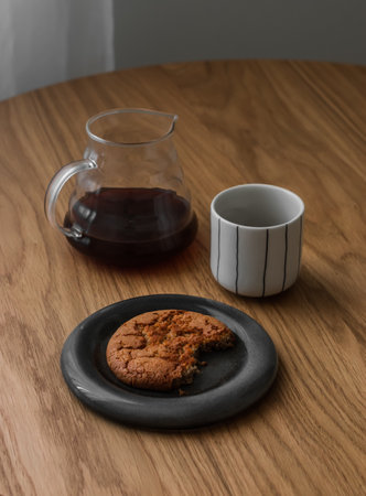 Coffee break - black coffee and peanut butter cookies on a round wooden tableの写真素材
