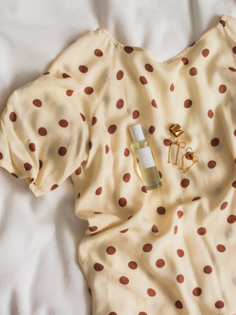 Women's viscose polka dot blouse, perfume, jewelry on a light background,top viewの写真素材