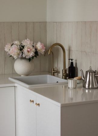 Cozy kitchen interior with a vase of peonies on the kitchen table. Minimalistic styleの写真素材