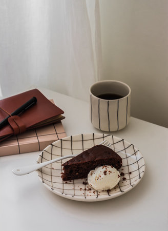 A piece of chocolate cake with a scoop of ice cream and coffee - delicious dessert on the tableの写真素材
