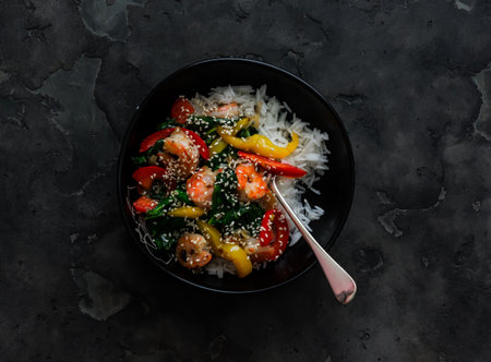 Basmati rice and vegetables, shrimp, spinach stir fry - delicious Asian style lunch on a dark background, top viewの写真素材