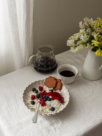 Breakfast, brunch served - cottage cheese with berry jam and blueberries, biscuits, black coffee on...