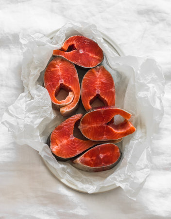 Pieces of fresh raw fish on paper on a light background, top viewの写真素材