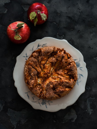 Charlotte pie with apples and cinnamon is a seasonal dessert on a dark background, top viewの写真素材