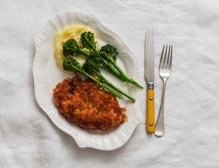 Chicken schnitzel, mashed potatoes, grilled broccoli on a light background, top viewの写真素材